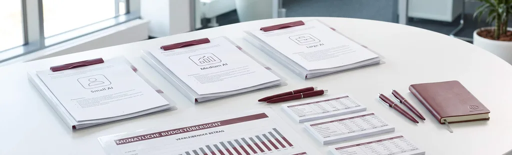 Klemmbretter mit KI-Paketstufen Small, Medium und Large AI neben einer monatlichen Budgetübersicht und Kostentabellen auf einem Bürotisch